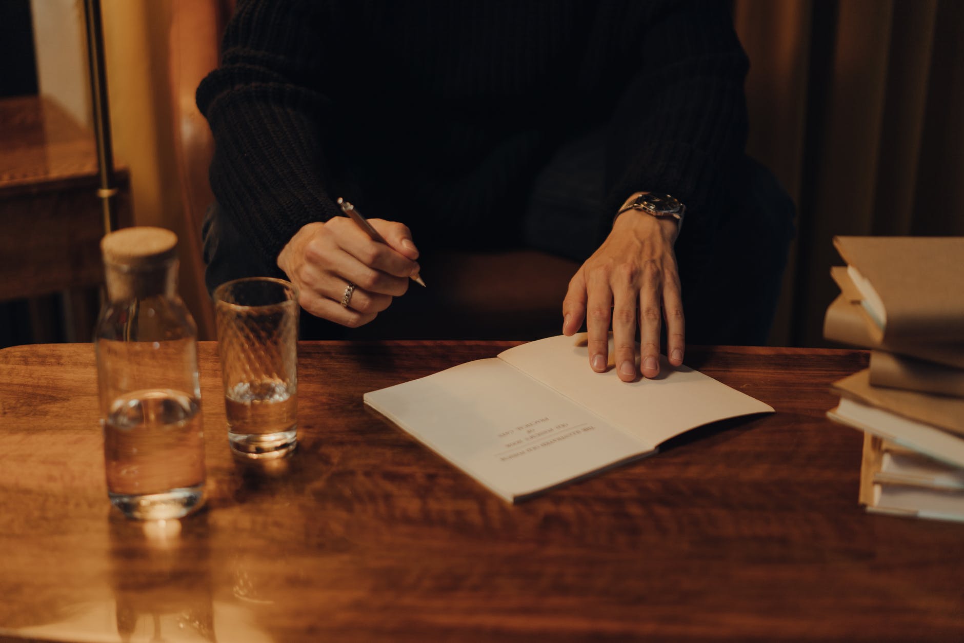 person in black long sleeve shirt holding white paper